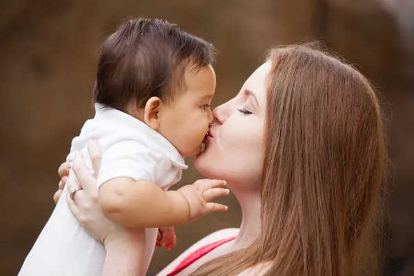 Mãe bonita beijando seu bebê — Fotografia de Stock