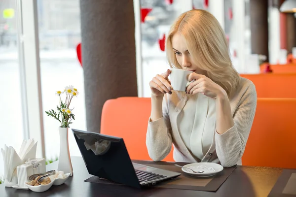 Młoda kobieta w kawiarni z laptopem — Zdjęcie stockowe