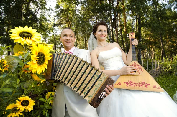 Snoubenka ránu balalajka, ženich hry na akordeon — Stock fotografie