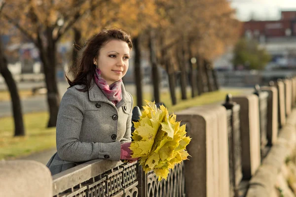 Girl with autumnal leafs in park — Stock Photo, Image