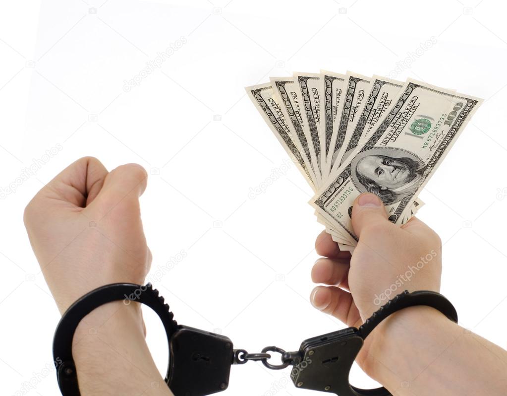 Hand   in shackle hold dollars