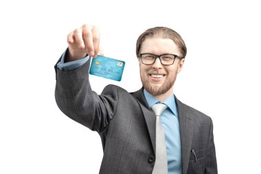 Mutlu iş adamının portresi kredi kartı ve gülümsemesiyle beyaz arka planda, izole bir şekilde duruyor.