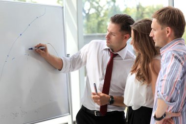 Beyaz tahta üzerinde bir şeyler açıklamaya lideri