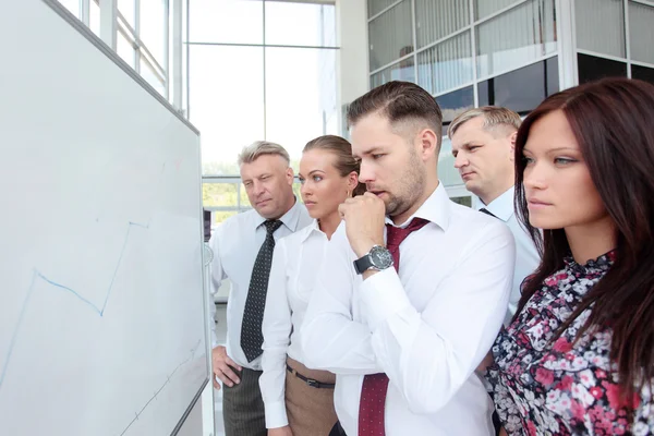 Jonge man die presenteert zijn ideeën op whiteboard — Stockfoto