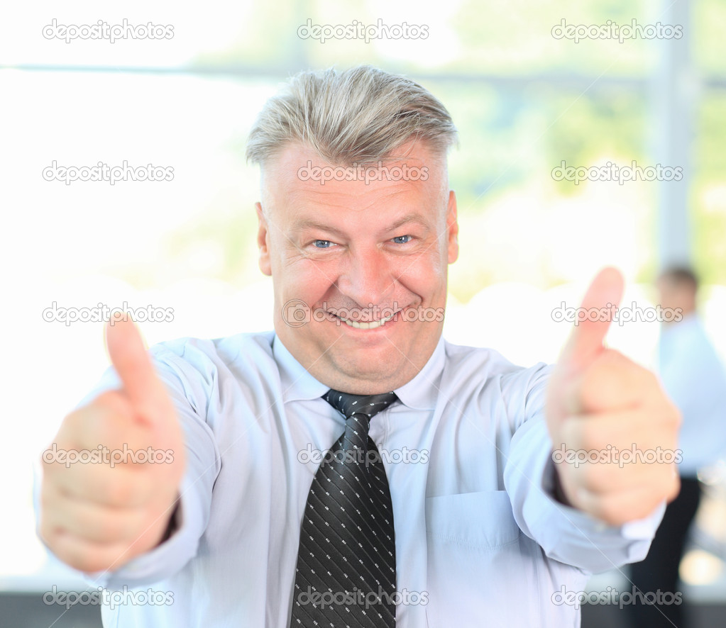 confident mature businessman giving you thumbs up