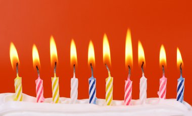 10 doğum günü mumları kırmızı arka plan ile parlak renkler yaktı.