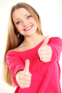 Güzel genç bir kadının baş parmak işareti gösteren yakın plan portresi.