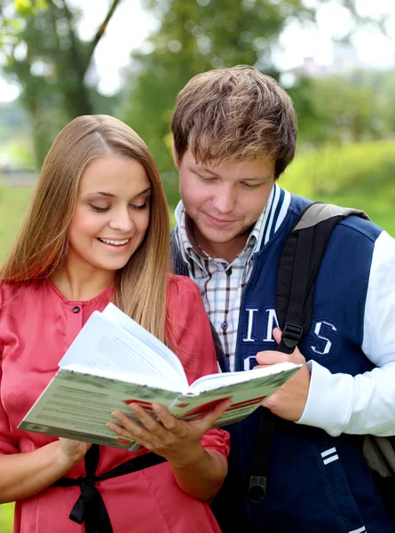 Ein paar Studenten mit einem Notizbuch im Freien — Stockfoto