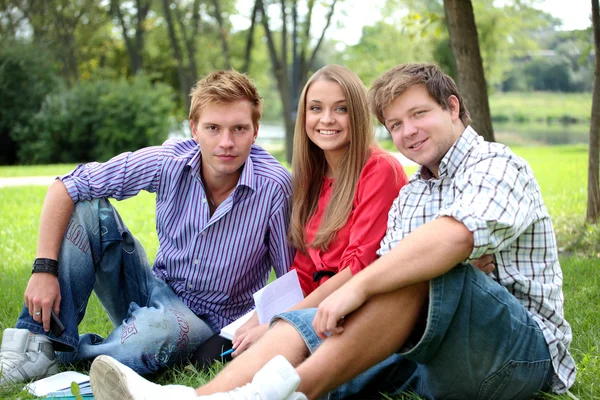 Glad grupp studenter med en bärbar dator leende utomhus — Stockfoto