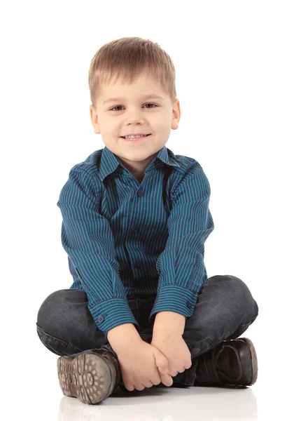 Porträt eines kleinen Jungen, der isoliert vor weißem Hintergrund sitzt — Stockfoto