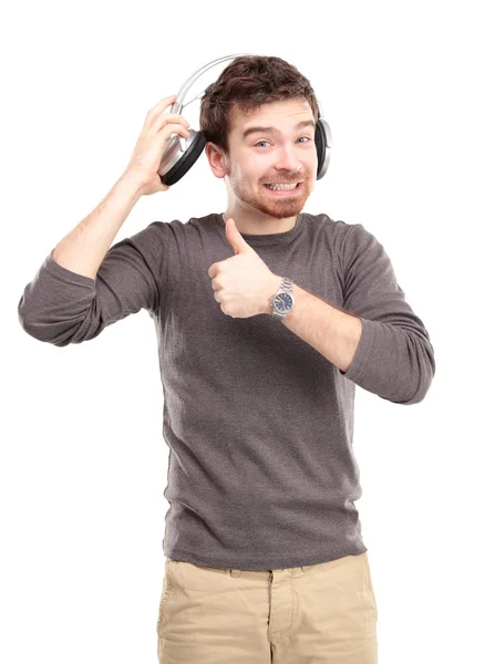 Jovem atraente usando fones de ouvido no fundo branco — Fotografia de Stock