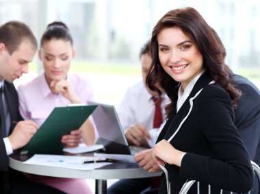 Portrait of successful businesswoman and business team at office meeting