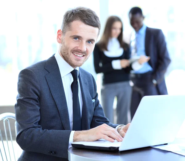 Affärsman som sitter vid sitt skrivbord på kontoret med en bärbar dator — Stockfoto