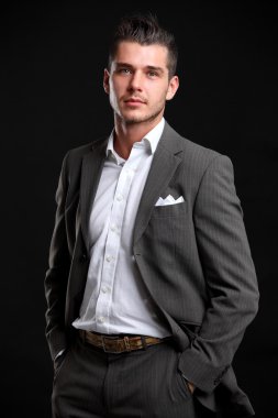 siyah arka plan üzerinde duran yakışıklı genç iş adamı