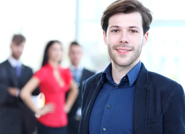 Happy smart business man with team mates discussing in the background — Stock Photo, Image