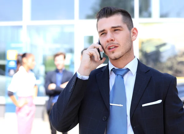 Glad framgångsrik ung affärsman talar i mobiltelefon — Stockfoto