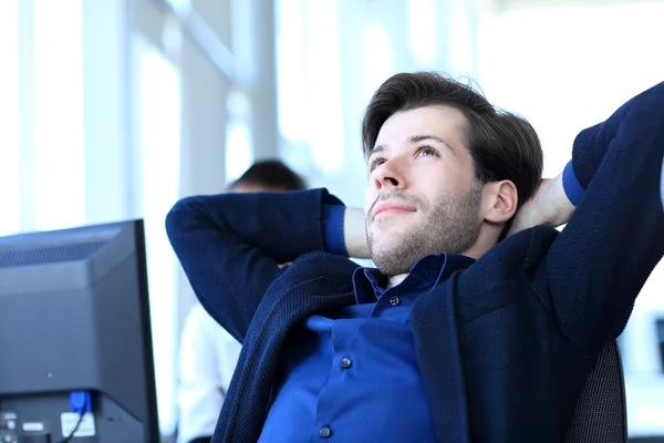 Zufriedener Geschäftsmann entspannt sich in seinem Büro — Stockfoto