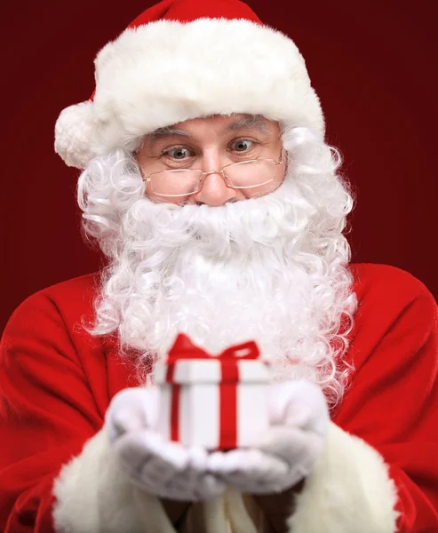 Photo of kind Santa Claus giving xmas present and looking at camera — Stock Photo, Image