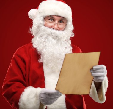 Mutlu Noel Baba 'nın portresi elinde Noel mektubu ve kameraya bakıyor.