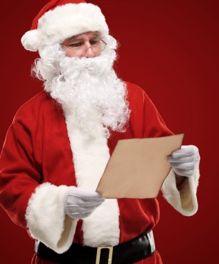 mutlu Noel Baba Noel mektubu holding ve mektuba bakarak portresi