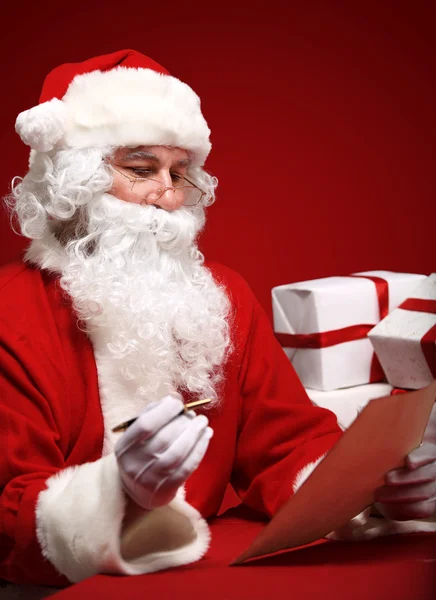Санта Клаус смотрит на конверт — стоковое фото