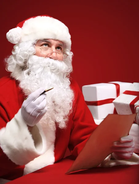 Санта Клаус смотрит на конверт — стоковое фото