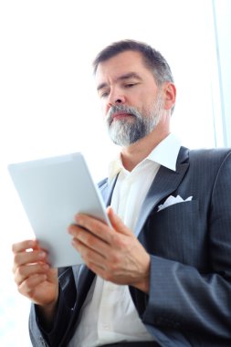 Ofiste tablet kullanan bir işadamı.