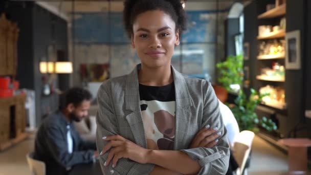 Улыбающаяся красивая африканка, американка, профессиональный менеджер, стоящая в современном офисе и смотрящая в камеру — стоковое видео