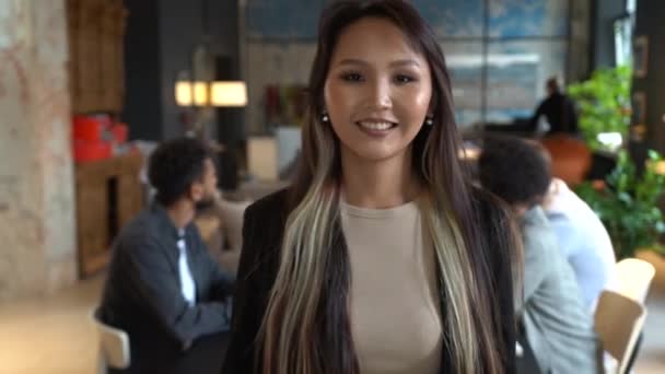 Mosolygó gyönyörű ázsiai nő szakmai menedzser alkalmazott áll a modern irodában nézi a kamera — Stock videók
