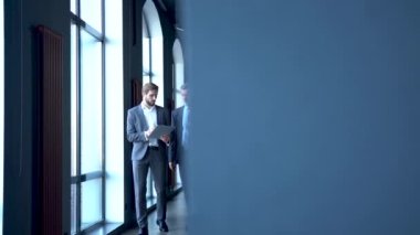İş adamları modern ofis lobisinde toplanıyor, yürüyor ve konuşuyorlar..