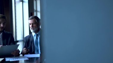 Şirket geliştirme stratejisini tartışan iki başarılı iş adamı ofiste beyin fırtınası yapıyor.