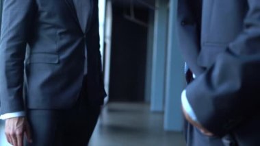 İki mutlu profesyonel iş adamı yönetici ofis toplantısında el sıkışıyor.
