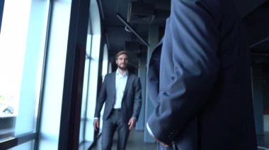 İki mutlu profesyonel iş adamı yönetici ofis toplantısında el sıkışıyor.