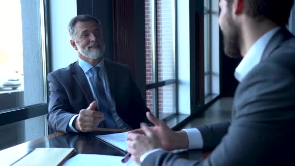 Business partners meeting in office building lobby and greeting with handshake — Stock Video