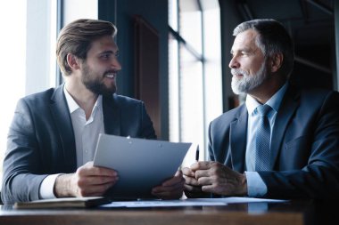 üst düzey ve genç işadamı tartışmak bir şey onların toplantı sırasında office arka plan.