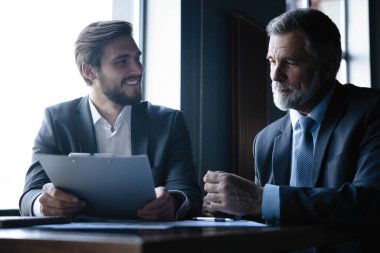 üst düzey ve genç işadamı tartışmak bir şey onların toplantı sırasında office arka plan.