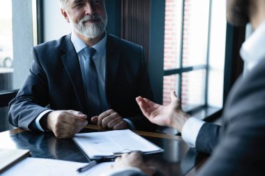 üst düzey ve genç işadamı tartışmak bir şey onların toplantı sırasında office arka plan.