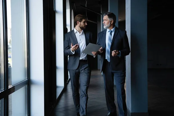 Twee collega 's communiceren in gang, partners lopen in het moderne kantoor — Stockfoto