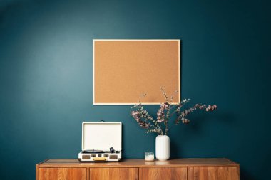 Yeşil duvardaki boş resim çerçevesi modeli. Zümrüt oturma odası tasarımı. Modern İskandinav tarzı iç mekan manzarası ve sanat eserleri duvarda. Ev sahneleme ve minimalizm kavramı