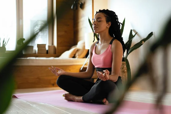 Jeune femme noire faisant du yoga à la maison en position lotus. — Photo