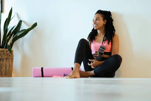 Satisfeito jovem mulher negra sentado e relaxante depois de seu trabalho para fora — Fotografia de Stock