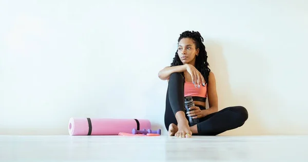 Satisfeito jovem mulher negra sentado e relaxante depois de seu trabalho para fora — Fotografia de Stock