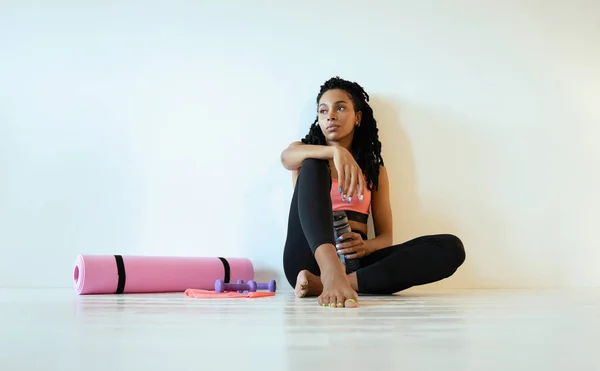 Nöjd ung svart kvinna sitter och kopplar av efter träningen — Stockfoto