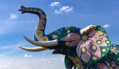 Sloní figurka proti modré obloze.