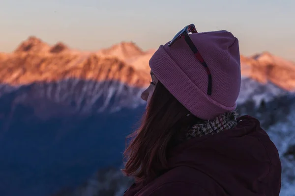 Wanderin blickt in den Himmel, Seitenblick mit Sonne auf die Berge im Schnee — Stockfoto