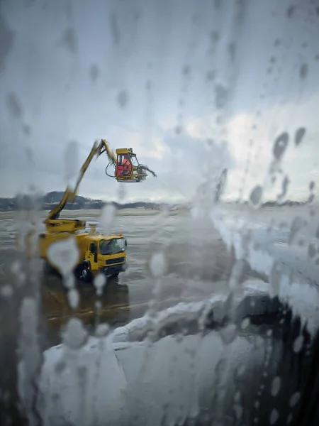 Ijsbestrijding van vleugelvliegtuigen op de luchthaven in de winteravond — Stockfoto