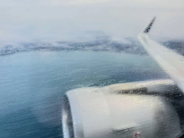 View from the porthole on the wing of the aircraft when approaching the landing in inclement weather — Stock Photo, Image