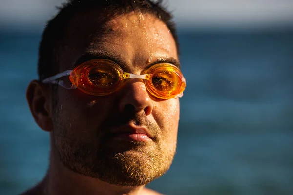 Young bearded man with swimming glasses on the sea background — Stok fotoğraf