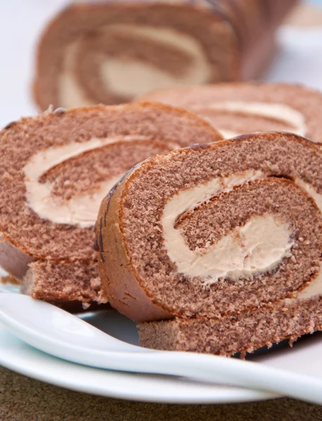 Swiss roll gąbki z krem na białym talerzu — Zdjęcie stockowe