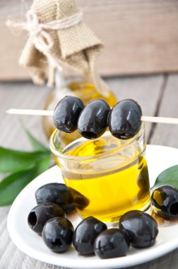 zeytin ve zeytinyağı ahşap zemin üzerine bir şişe ile plaka